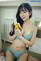 A woman in a blue lingerie holding a banana.