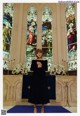 A woman standing in front of a stained glass window.