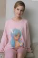 A woman sitting on a couch wearing a pink sweatshirt with a bunny on it.