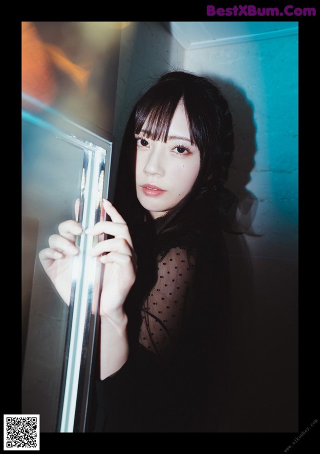 A woman holding a mirror in front of her face.