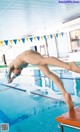 A man diving into a swimming pool from a diving board.