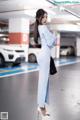 A woman in a blue dress standing in a parking garage.