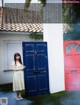 A woman standing in front of a blue and pink door.